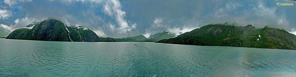 Panorama of a turquoise fjord between green cliffs